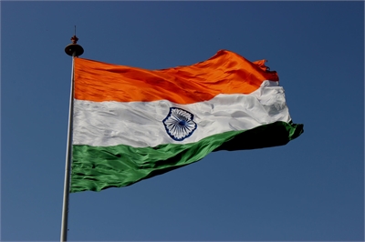 [ai] The Indian national flag waving in the wind, displaying its three horizontal bands of saffron, white, and green, with the Ashoka Chakra in navy blue in the center.